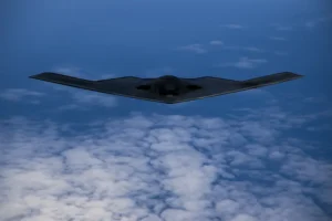 b2 stealth bomber flying above the clouds, demonstrating its unique flying wing design and stealth technology, crucial for executing long-range, undetected military missions.