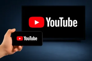 Person holding smartphone with YouTube TV logo displayed on screen, showing YouTube TV app on mobile and TV."