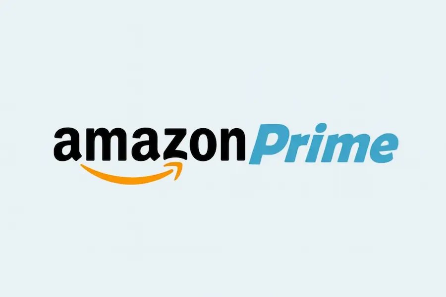 Amazon Prime logo featuring bold black "amazon" with a signature orange smile-shaped arrow and a light blue "Prime" text, on a soft gray background