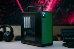 Framework Desktop 2025 modular mini-ITX workstation on a creator’s desk, black chassis with glass side panel and green front tiles, designed for AI and video editing.